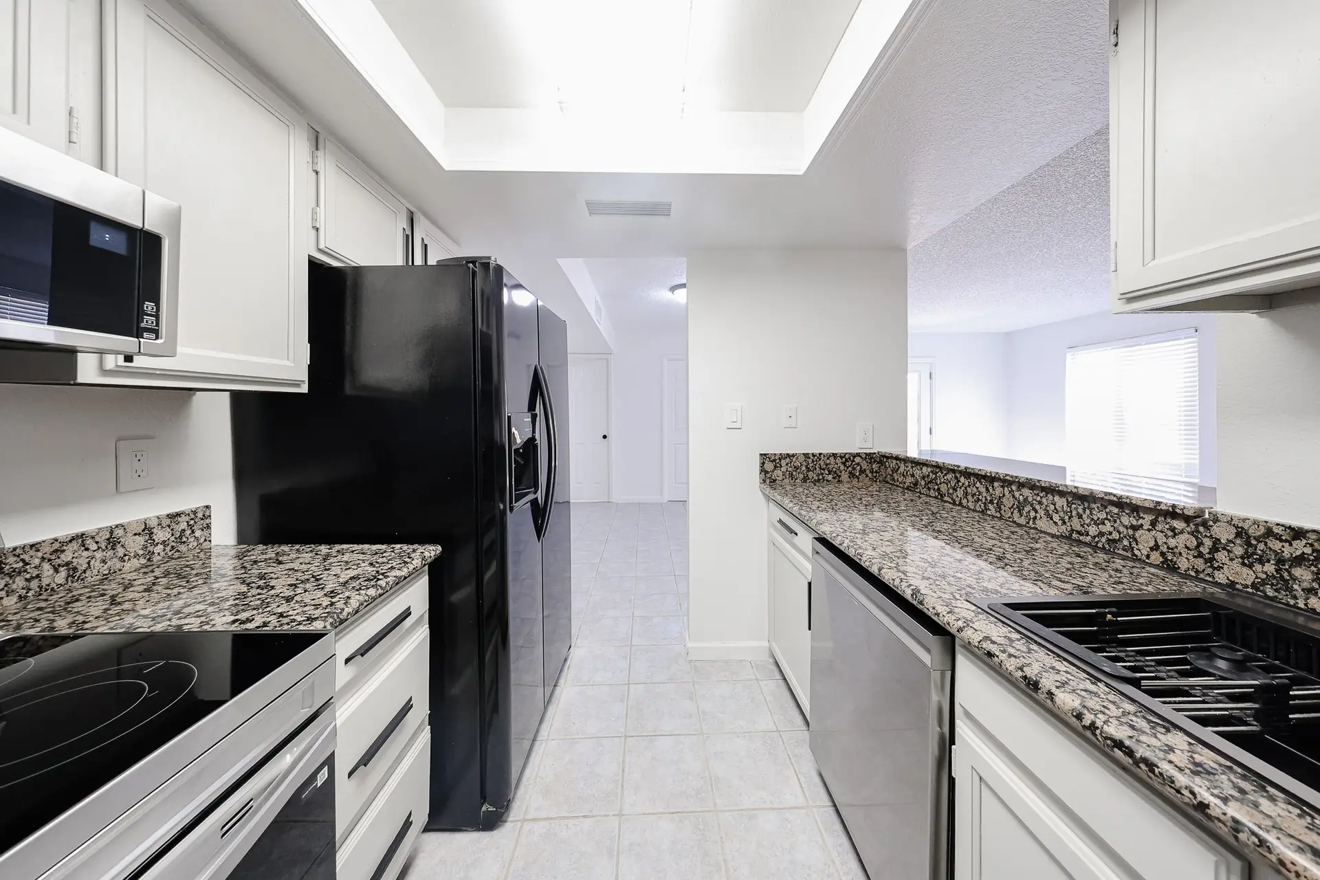 Updated Kitchen Updated kitchen with white cabinetry and dark appliances