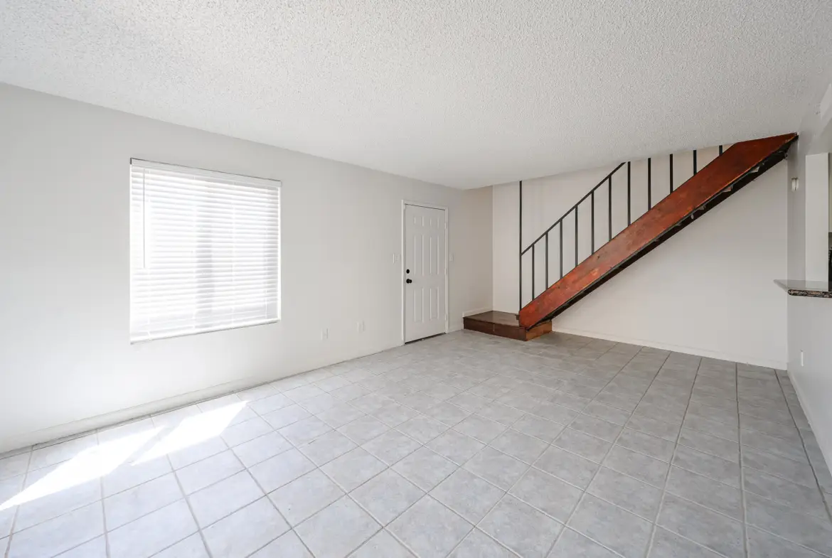 Living room view showing the staircase to the second floor