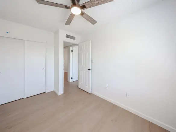Second view of the third bedroom with ceiling fan
